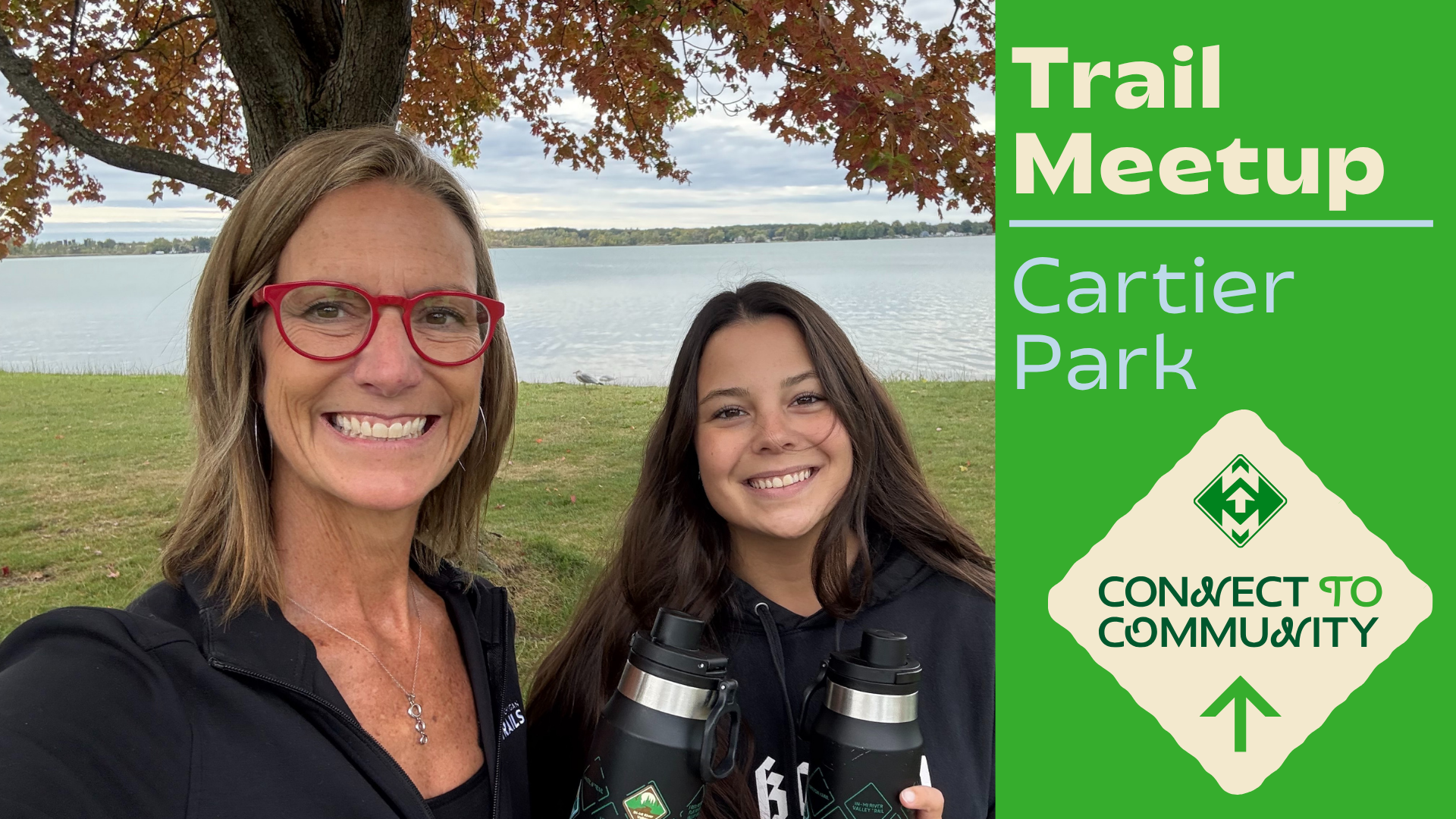 Trail meetup at Cartier Park. Two smiling people with water bottles by lake and autumn tree. Connect to community.
